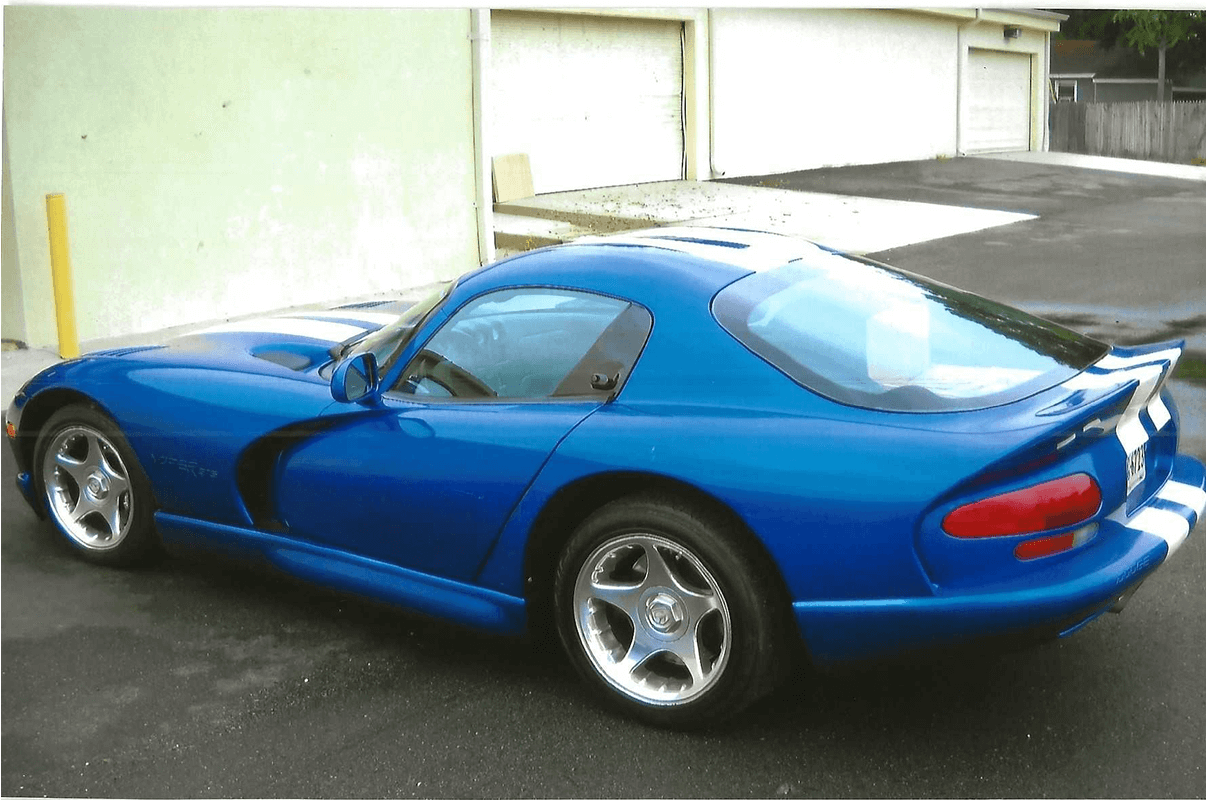Blue sports car parked outside garage