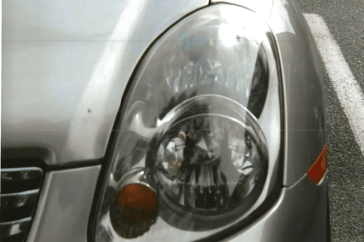 Damaged headlight on silver vehicle
