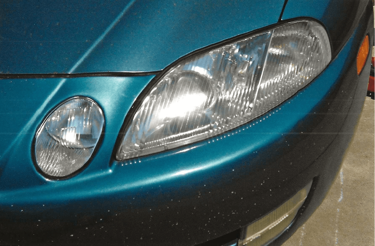 Close-up of a blue car's headlight and turn signal.
