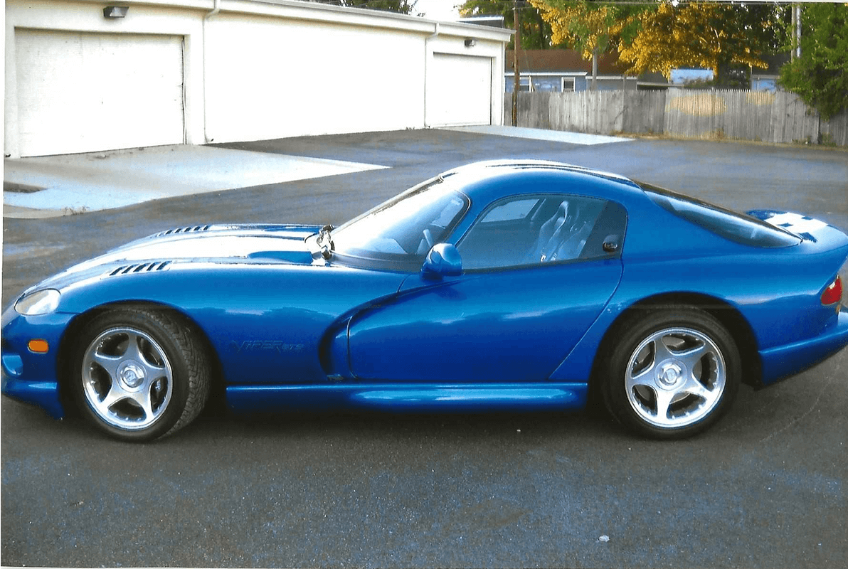 Blue car with silver wheels in driveway